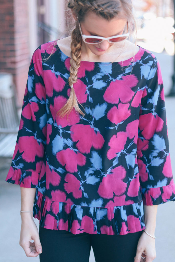 Fashion blogger, Leigha Gardner, of The Lilac Press wearing a floral pleated blouse while hanging out downtown.