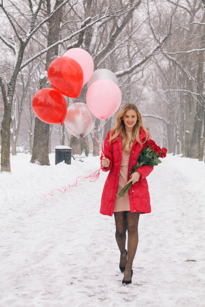 Lifestyle blogger Leigha Gardner of The Lilac Press in a blush pink Asos dress, red down puffer jacket heading down Commonweath Ave with Valentine's Day balloons and roses in tow.
