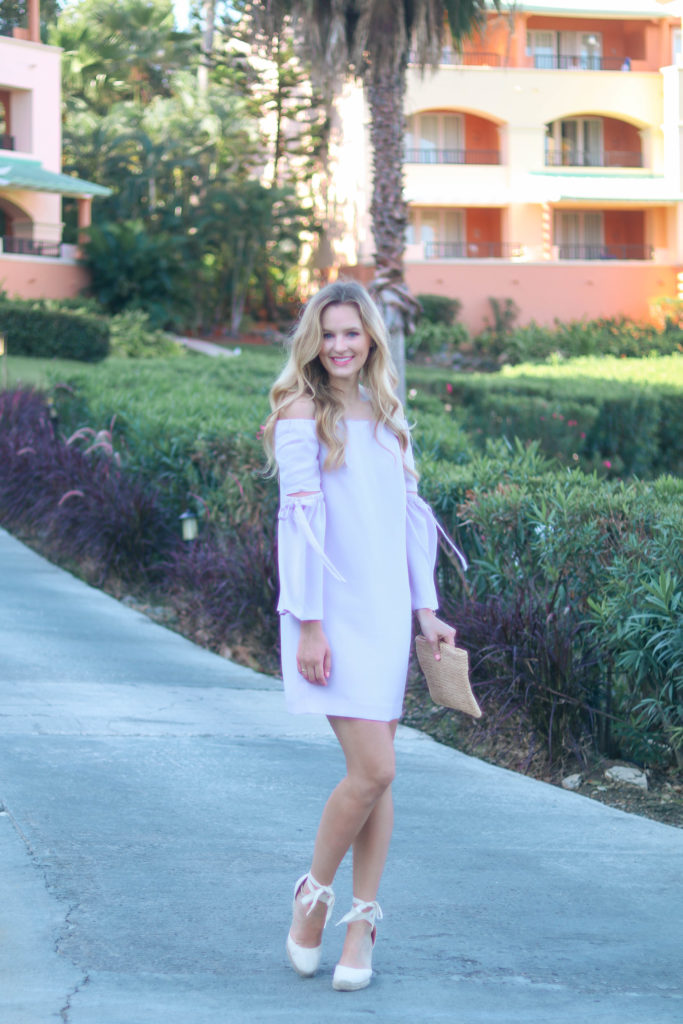 Style blogger, Leigha Gardner, of The Lilac Press wearing a lilac off-the-shoulder dress with bell sleeves and cutouts from Club Monaco.
