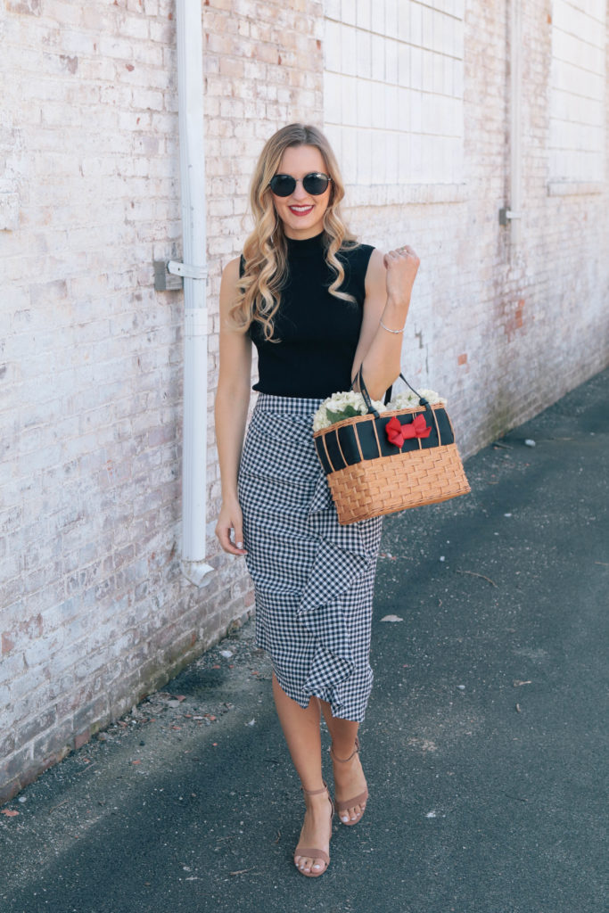 Style blogger Leigha Gardner, of The Lilac Press, wearing a navy gingham skirt, black tank and a basket tote with a bright red bow (sharing tips on mixing black and navy).