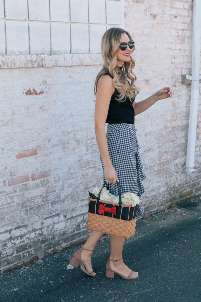 Style blogger Leigha Gardner, of The Lilac Press, wearing a navy gingham skirt, black tank and a basket tote with a bright red bow (sharing tips on mixing black and navy).