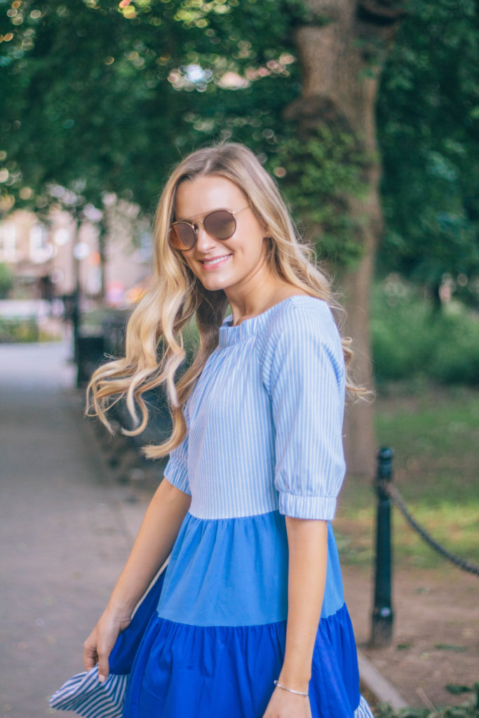Style blogger, Leigha Gardner, of The Lilac Press sharing a favorite blue color blocked striped dress twirling around Washington Square Park, NYC.