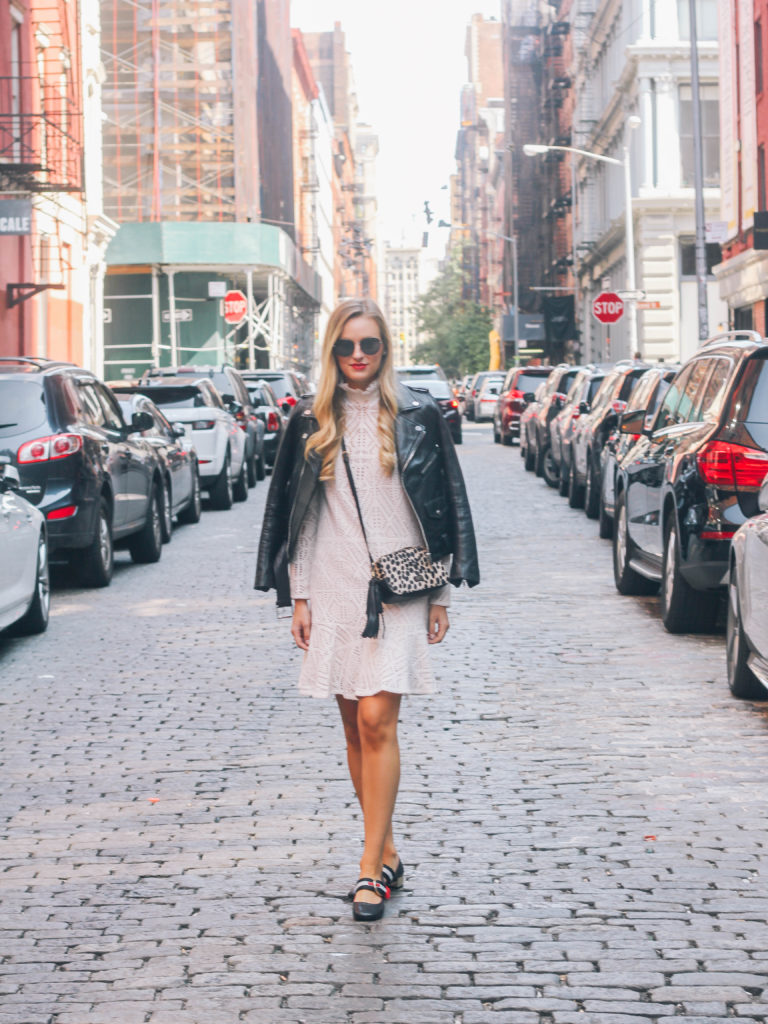 Style blogger, Leigha Gardner, of The Lilac Press wearing a white See by Chloe lace dress coupled with a leather jacket in the cobblestone streets of Soho.
