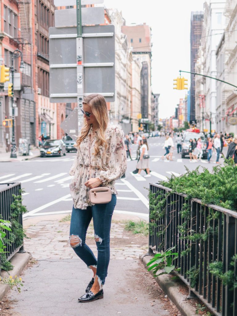 Fashion blogger, Leigha Gardner, wearing Zimmermann maples frill top, L'Agence distressed jeans, Milly crossbody and Chanel sunglasses during fashion week in NYC. 