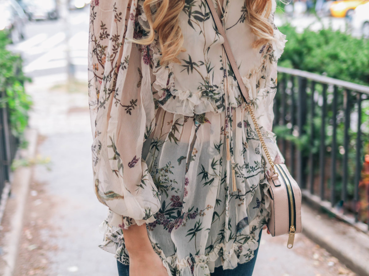Fashion blogger, Leigha Gardner, wearing Zimmermann maples frill top, L'Agence distressed jeans, Milly crossbody and Chanel sunglasses during fashion week in NYC. 