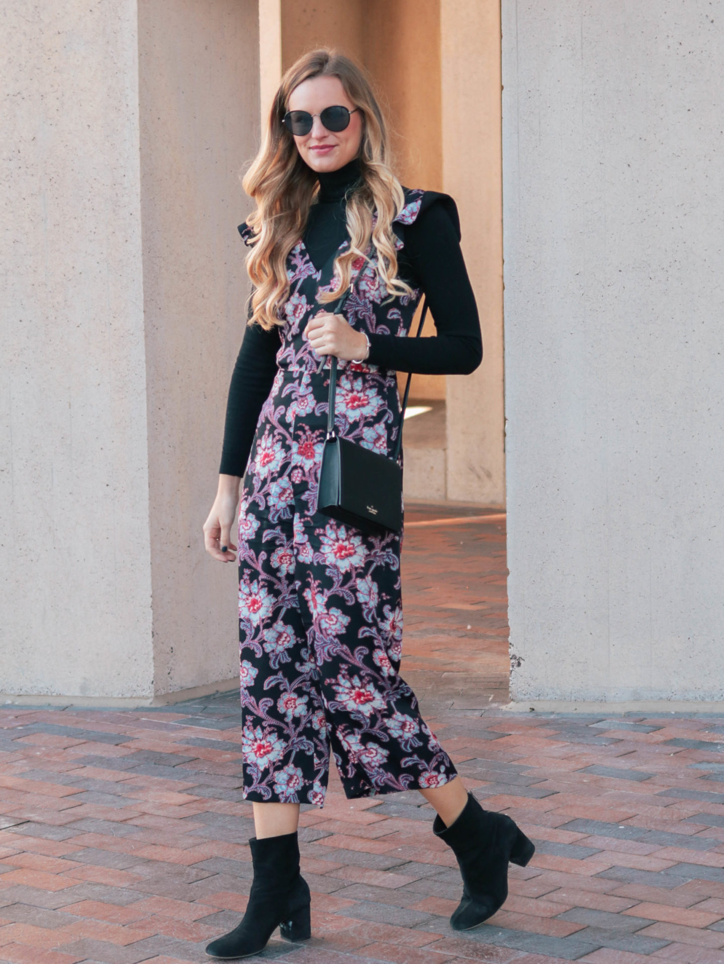 Fashion blogger, Leigha Gardner, of The Lilac Press wearing donning a black turtleneck to transition a floral jumper from warm weather wear to winter wear.