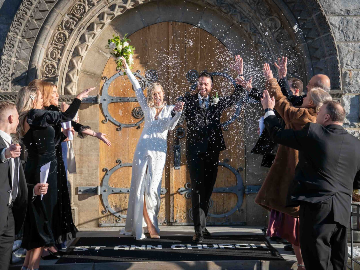 Bride and groom leaving the church after being married, throwing confetti