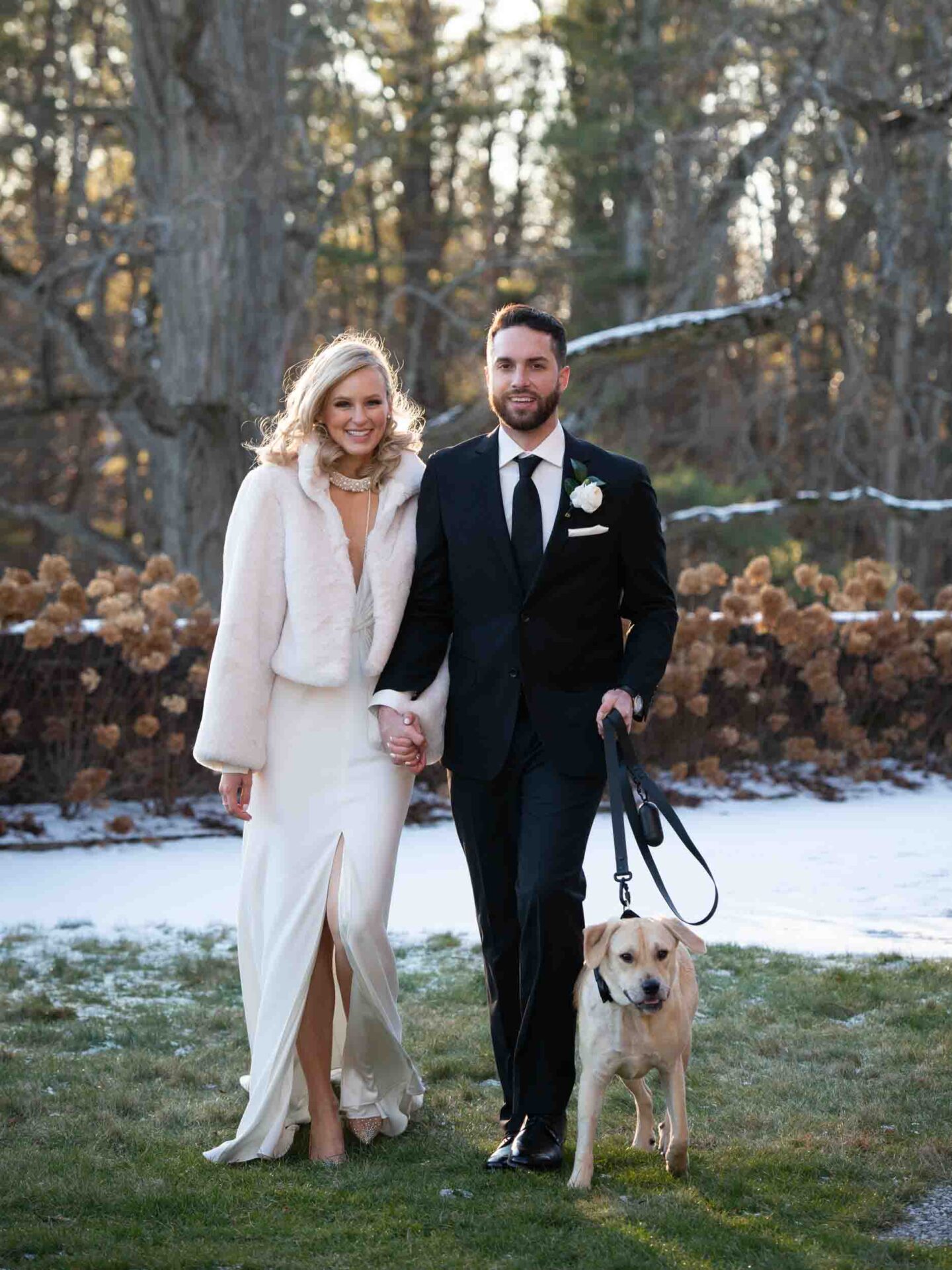 Bride and groom walking with puppy